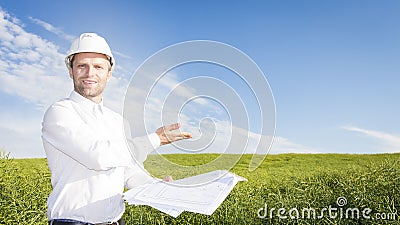 Geodesist with drawings on ground for building building. Builder in white helmet and project documentation on green meadow Stock Photo