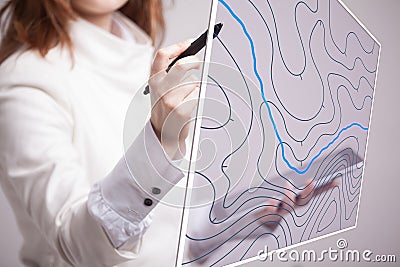 Geographic information systems concept, woman scientist working with futuristic GIS interface on a transparent screen. Stock Photo