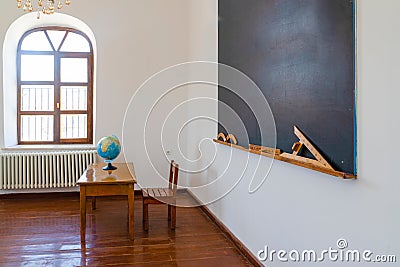 For the geography lesson, the globe stands on the teacher`s desk. Tools and materials for math lesson stand on the chalkboard Editorial Stock Photo