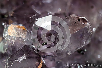 Gemstone Amethyst closeup as a part of cluster geode filled with rock Quartz crystals. Stock Photo