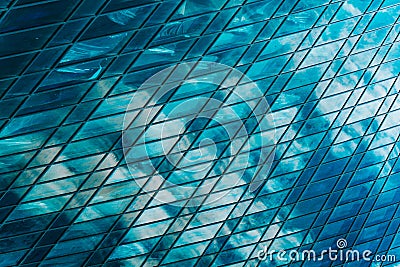 Geometry and lines of a modern business center. Clouds are reflected in the glass windows of a high-rise skyscraper of a Stock Photo