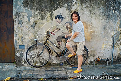 George Town, Malaysia - March 10, 2017: Little Children on a Bicycle, popular mural street art that unknown tourists Editorial Stock Photo