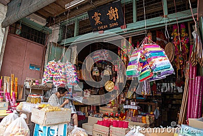 A woman read newspaper at the joss stick shop house. Editorial Stock Photo