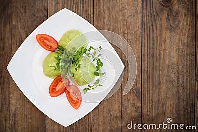 Georgian dumplings Khinkali of spinach dough with meat and tomato spicy sauce satsebeli. Wooden background. Top view. Close-up Stock Photo