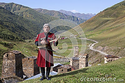 Georgian man plays local musical instrument of panduri and sings traditional svanetian songs in Ushguli, Caucasus Mountains, Georg Editorial Stock Photo