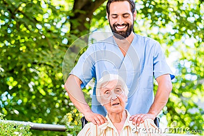 Geriatric nurse giving senior woman massage Stock Photo