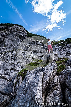 German Alps. August 2017: Young girl standing with on top of the rock and looking into a wide valley Editorial Stock Photo