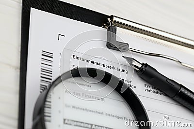 German annual income tax return declaration form blank on A4 tablet lies on office table with pen and magnifying glass Stock Photo