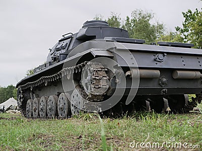 German medium tank of the Second World war in working order. the tank is painted black against a background of green trees in summ Stock Photo