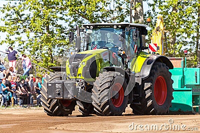 German claas axion tractor drives on track by a traktor pulling event Editorial Stock Photo