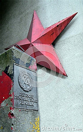 German Democratic Republic sign and red star near Checkpoint Charlie between east and west sectors during the Cold War Editorial Stock Photo
