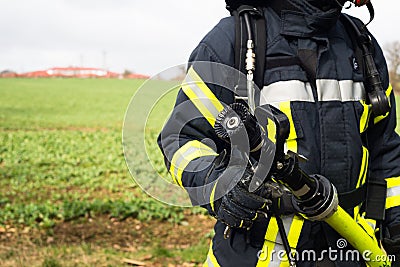 German Firefighter with water hose in action Stock Photo