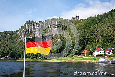 German flag in front of Elbe sandstone mountains at Rathen near Bastei Bridge (Basteibrucke) - Saxony, Germany Stock Photo