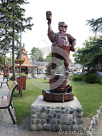 German man drinking beer. Statue tribute to the tradition and the beer spirit of Villa General Belgrano. Wooden statue in central Editorial Stock Photo