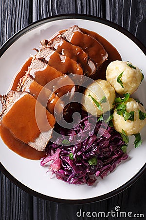 German roast pot Sauerbraten served with potato dumplings and re Stock Photo
