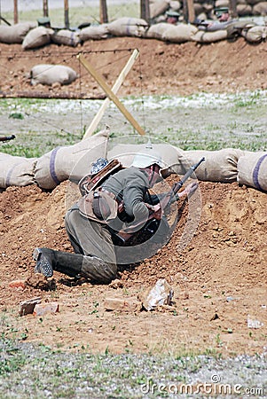 German soldier-reenactor hides behind the sand hill Editorial Stock Photo