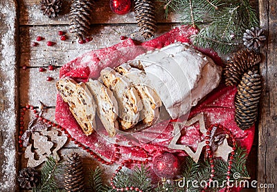 German Stollen Christmas Cake and Celebration Decorations. Traditional baking with Berries, Nuts, Marzipan. Stock Photo