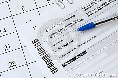 German tax form with pen lies on office calendar. Concept of tax paying in Germany Editorial Stock Photo