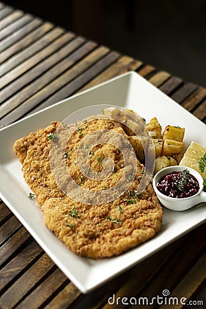 German veal schnitzel cutlet with potato and red berry sauce Stock Photo
