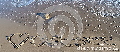 The german word Ostsee Baltic Sea and a heart written into the sand of the beach Stock Photo