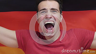German Young Man Celebrates holding the Flag of Germany in Slow Motion Stock Photo