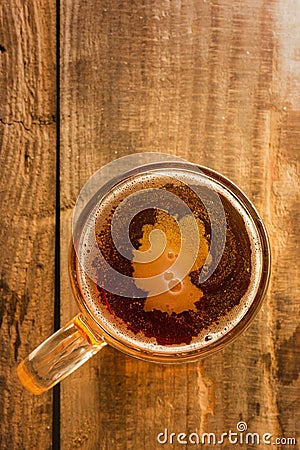 Germanic beer concept, Germany silhouette on foam in beer glass on wooden table. Stock Photo