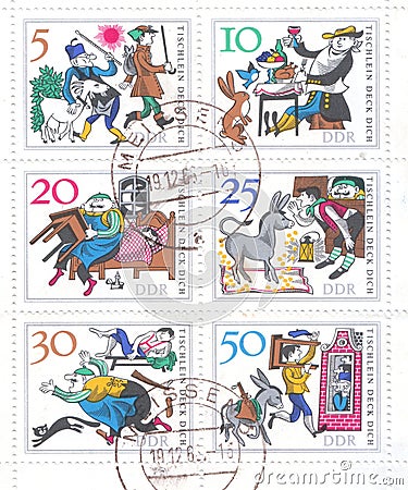 A block of postage stamps from Germany which depicts a German folk tale about a magic table, a donkey and a truncheon Editorial Stock Photo