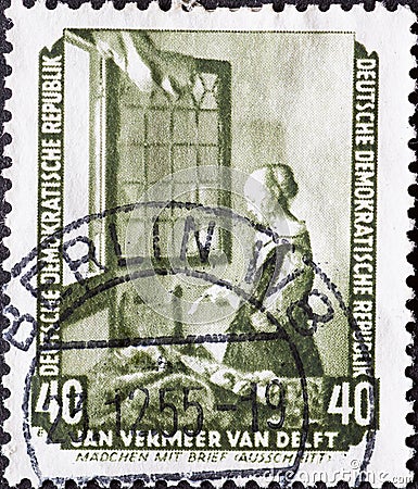GERMANY, DDR - CIRCA 1955 : a postage stamp from Germany, GDR showing Girl reading a letter at the window by Jan Vermeer van Delf Editorial Stock Photo
