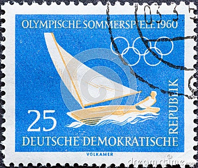 GERMANY, DDR - CIRCA 1960 : a postage stamp from Germany, GDR showing a sailboat in the wind with a single-handed sailor. Text: O Editorial Stock Photo