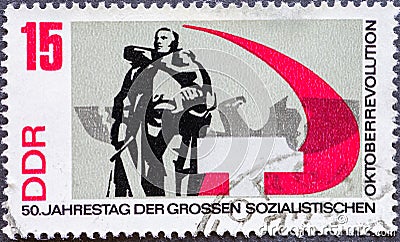 GERMANY, DDR - CIRCA 1967: a postage stamp from Germany, GDR showing a sculpture. Text: 50th anniversary of the great socialist Oc Editorial Stock Photo