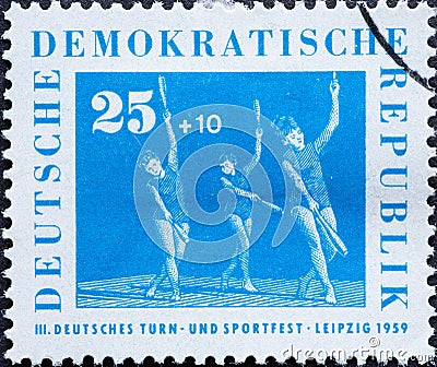 GERMANY, DDR - CIRCA 1959 : a postage stamp from Germany, GDR showing some women doing gymnastics with clubs. German Gymnastics an Editorial Stock Photo