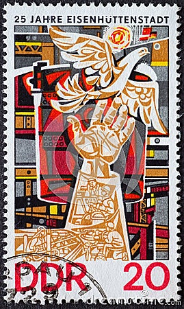 GERMANY, DDR - CIRCA 1975 : a postage stamp from Germany, GDR showing a work of art with a hand and a dove of peace. 25 years of E Editorial Stock Photo