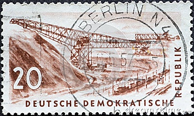GERMANY, DDR - CIRCA 1957 : a postage stamp from Germany, GDR showing the drawing of a conveyor bridge in the open pit for lignite Editorial Stock Photo