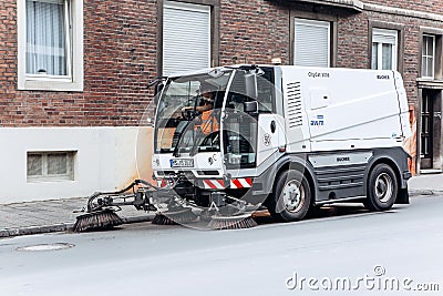 A special truck or street cleaning vehicle rides along the road and cleans the street from dirt and dust. Editorial Stock Photo