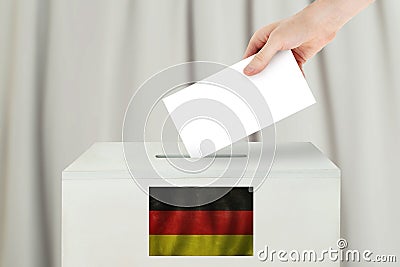 Germany Vote concept. Voter hand holding ballot paper for election vote on polling station Stock Photo