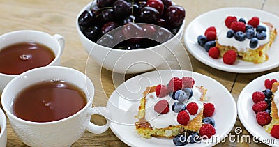 Geschmackvolles Frühstück im Café des Bonbons backen mit verschiedenen Beeren und Schalen mit Tee stock video footage Geschmackvolles Frühstück im Café des Bonbons backen mit verschiedenen Beeren und Schalen mit Tee stock video footage