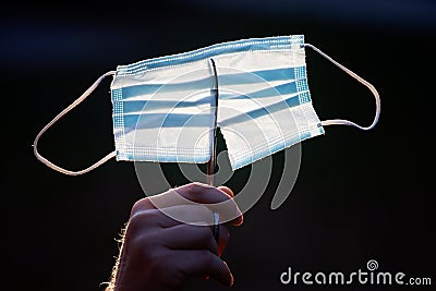 Close up of scissors while cutting a surgical mask. End of coronavirus pandemic Stock Photo
