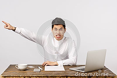 Get out of my office, go. Angry, aggressive and outraged asian male boss demand leave, pointing at exit and shouting Stock Photo