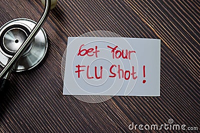 Get Your Flu Shot! write on sticky note isolated on wooden table Stock Photo