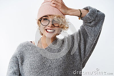 Getting all trendy this winter season. Portrait of charming blond european girlfriend in sweater and pink beanie pulling Stock Photo