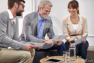 Getting approval from the boss. Shot of a group of business professionals looking over paperwork together. Stock Photo