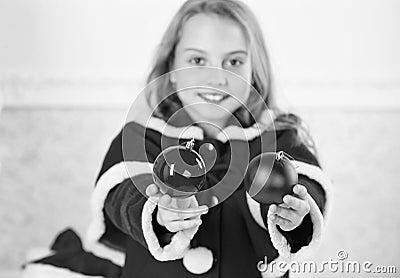 Getting child involved decorating. How to decorate christmas tree with kid. Girl smiling face hold balls ornaments white Stock Photo