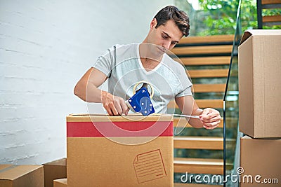 Getting everything ready for the move. a young man packing up his belongings into boxes before moving out. Stock Photo