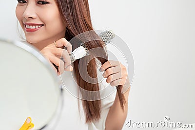 Getting rid of tangles. Beautiful young woman looking at her ref Stock Photo