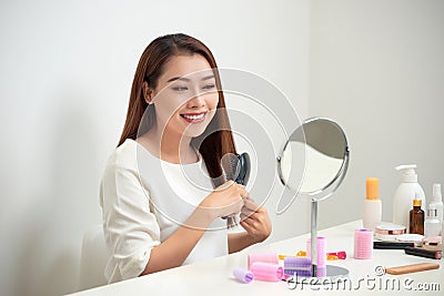Getting rid of tangles. Beautiful young woman looking at her ref Stock Photo