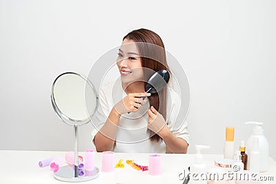 Getting rid of tangles. Beautiful young woman looking at her ref Stock Photo