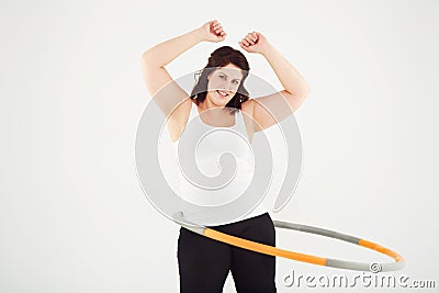 Getting in shape her own way. Cropped view of a woman hula dancing while isolated on white. Stock Photo