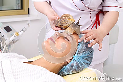 Getting snail skin cleaning at beauty salon. Stock Photo