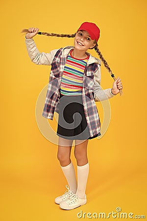 Getting your hairstyle to last all day. Happy child with braided hairstyle yellow background. Small cute girl smile with Stock Photo