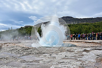 Strokkur geyser erupting and many tourists waiting Editorial Stock Photo